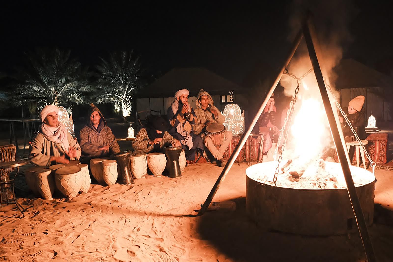 Berber musicians playing drums around the fire pit at a Morocco Desert Nights camp